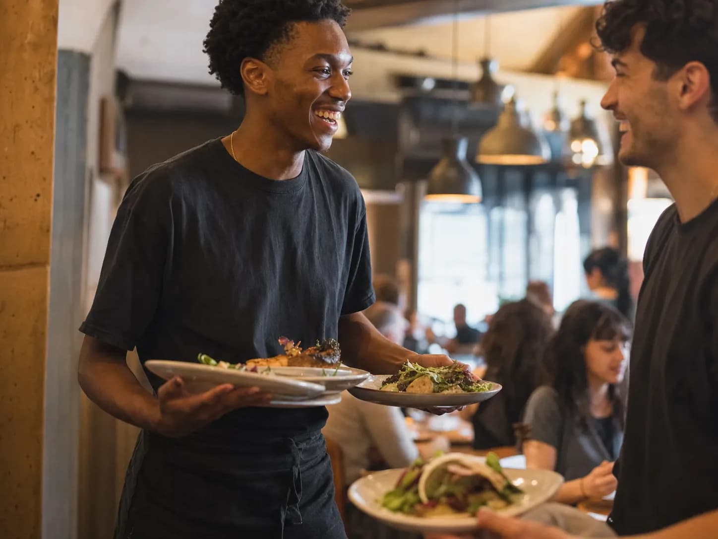 Serveur portant des assiettes en plein service